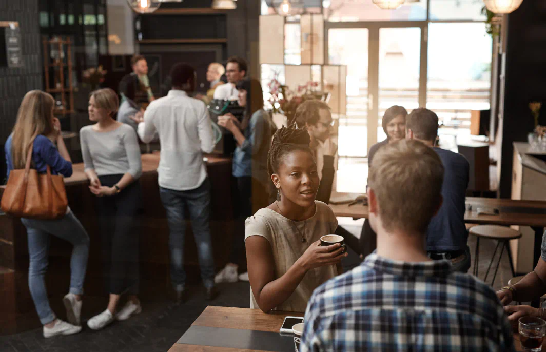 A busy café with people conversing and drinking coffee.