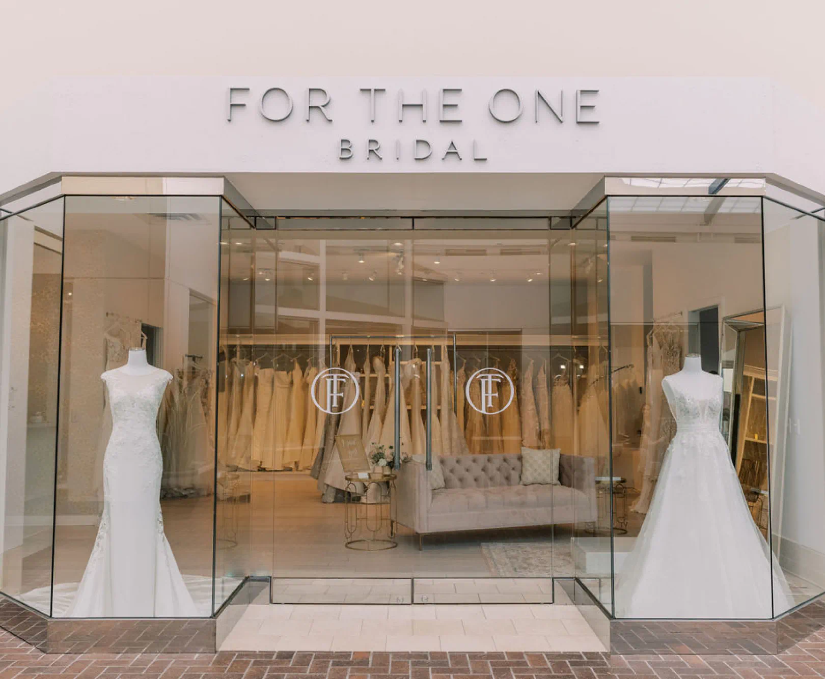 The front entrance of For The One, many bridal dresses can be seen through the store window.