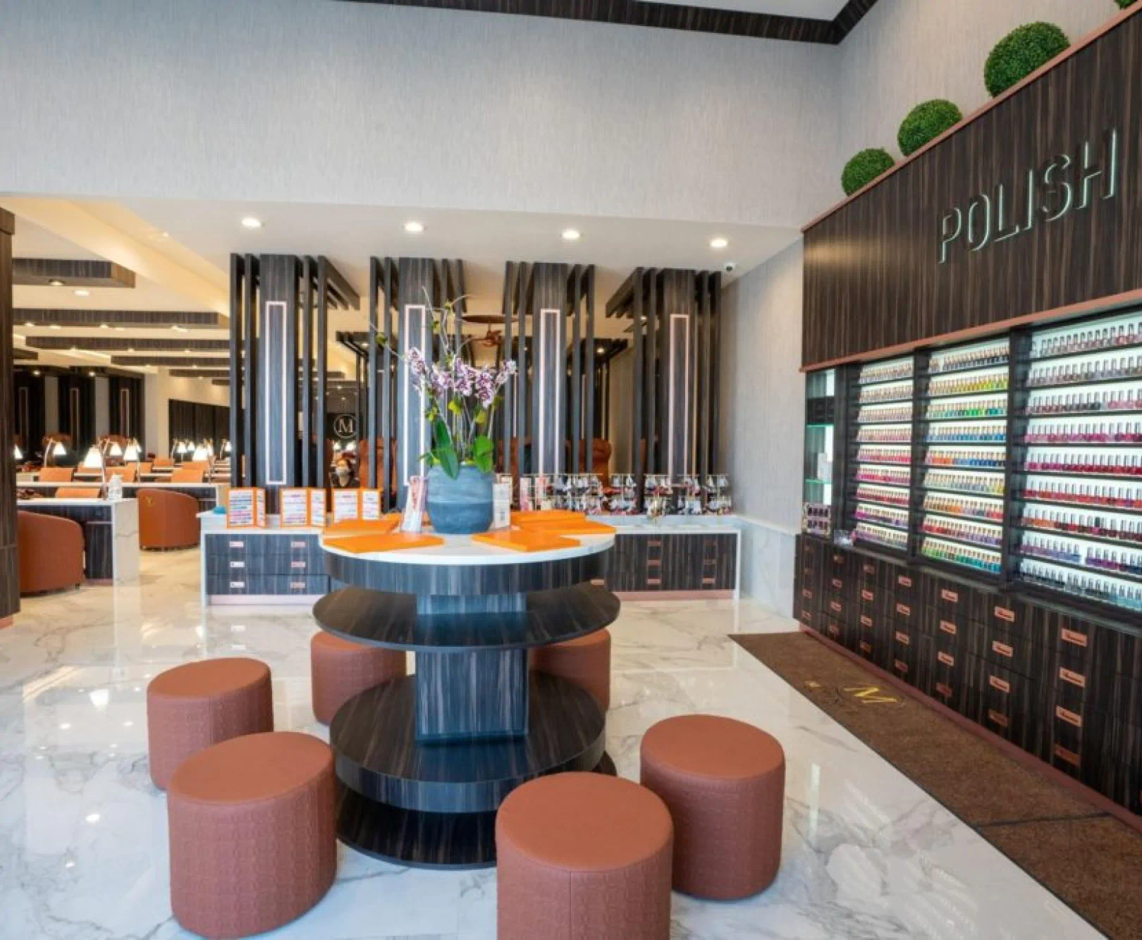 An upscale nail salon with a display of nail polishes on a backlit shelf