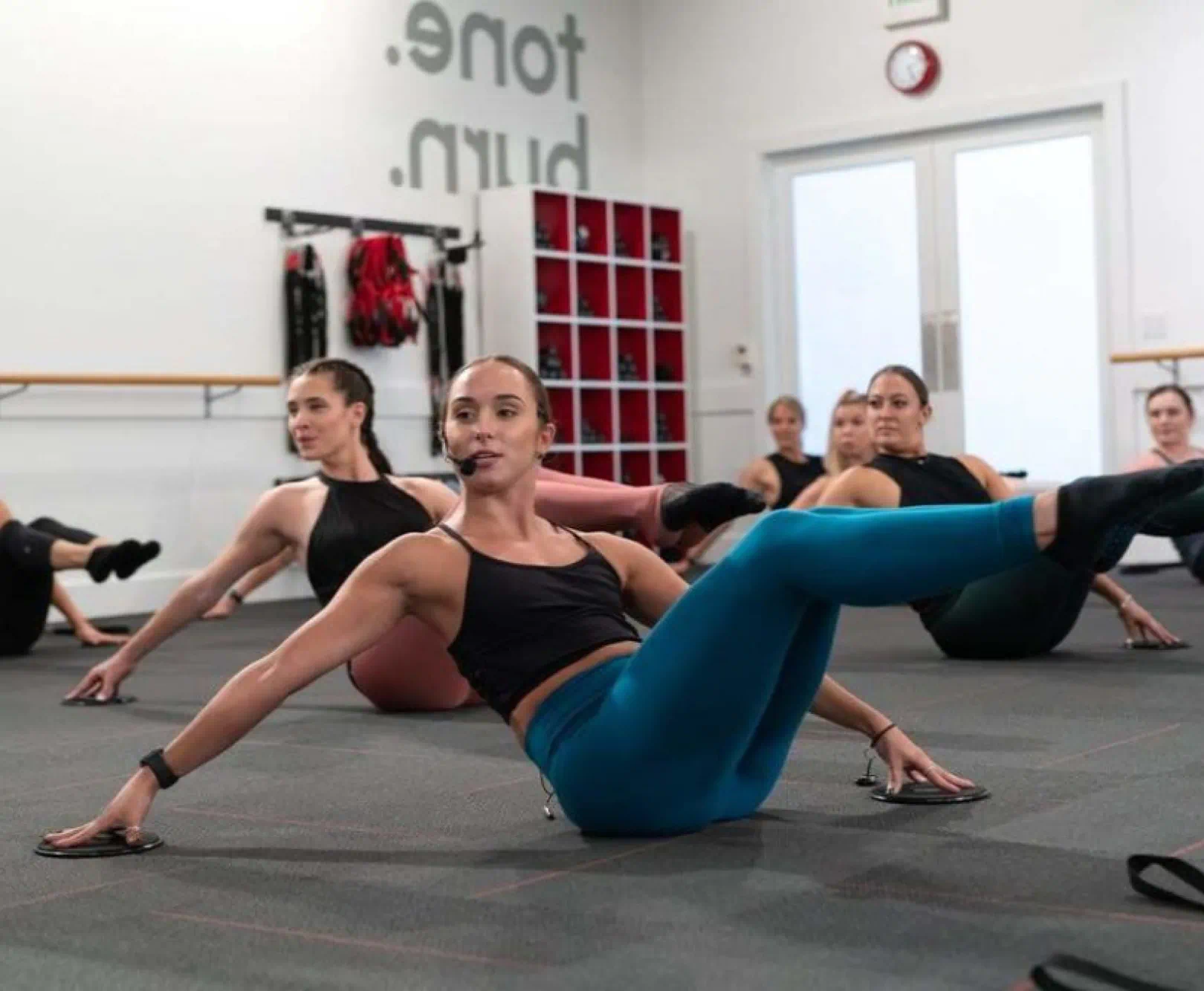 women performing barre exercises in a dance studio