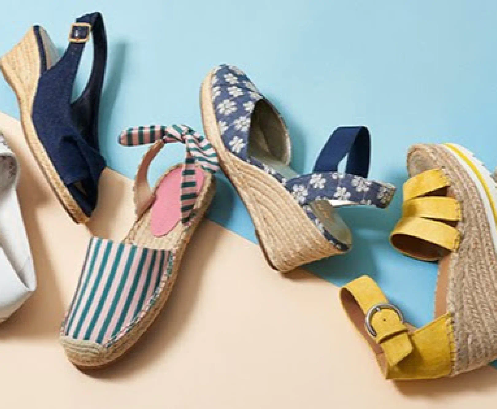 A collection of five colorful wedge sandals on a light blue and beige background.