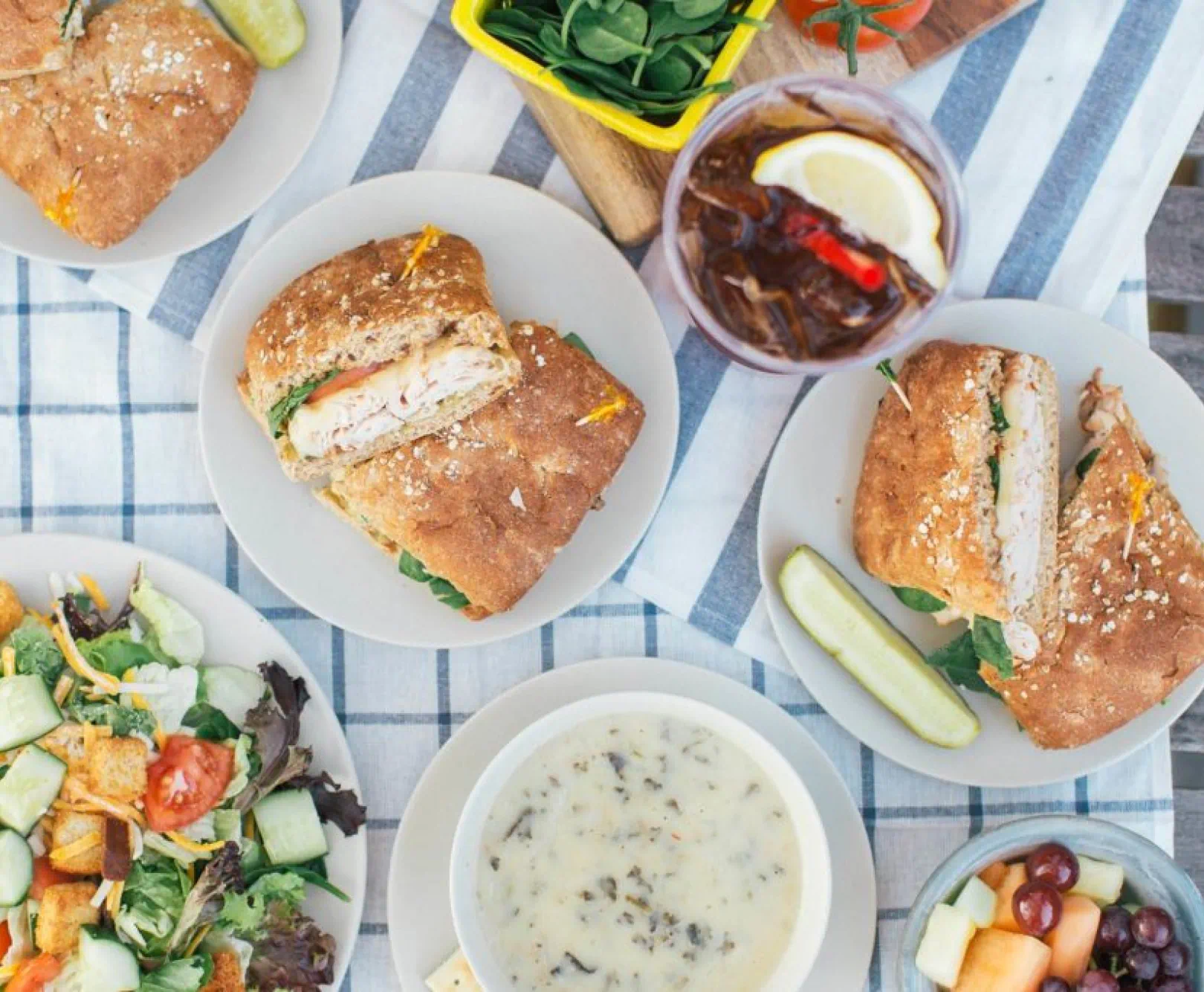 sandwiches, soup, and salad spread on table